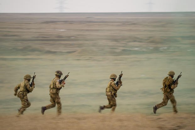 Servicemen run during the Steadfast Dart 2025 exercise