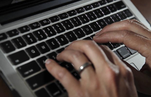 person types on a laptop keyboard in North Andover, Mass. 