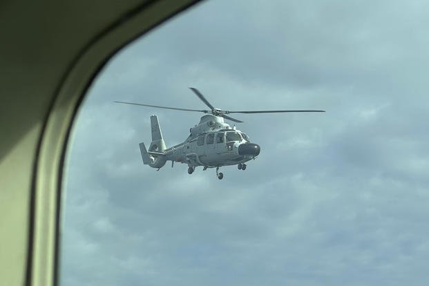 A Chinese military helicopter flies close to a Philippine Bureau of Fisheries and Aquatic (BFAR) aircraft above Scarborough shoal