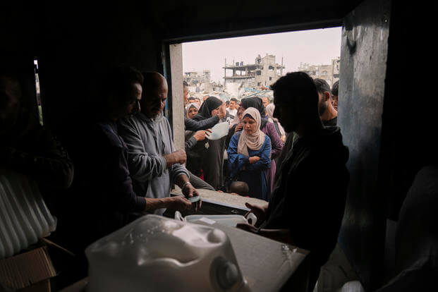 Palestinians receive humanitarian aid distributed by UNRWA, the U.N. agency helping Palestinian refugees in Jabaliya