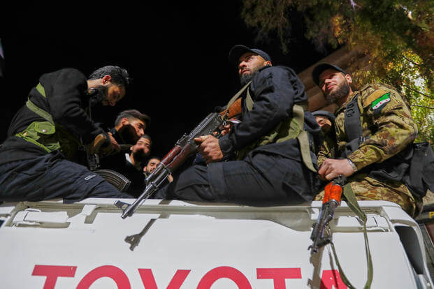 Syria's security forces stand on their vehicle