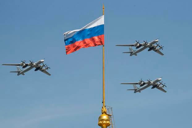 Russian Tu-95 strategic bombers fly past a Russian flag at the Kremlin