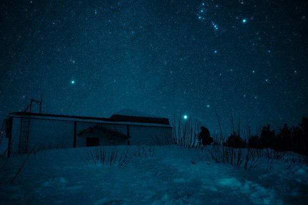 An astronomer at the Special Astrophysical Observatory in the Caucasus Mountains takes a photo of Orion's Belt, which is seen at the background. 