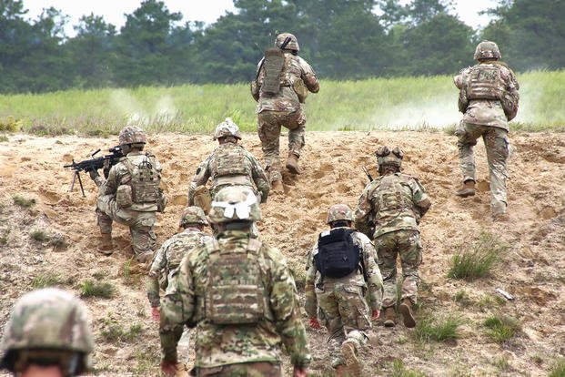 U.S. Army fire teams head over the bunker during a squad live fire assault mission 