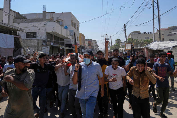 Palestinians, some armed, carry the body of Farouq Khattab, 29, who was killed in an Israeli army airstrike