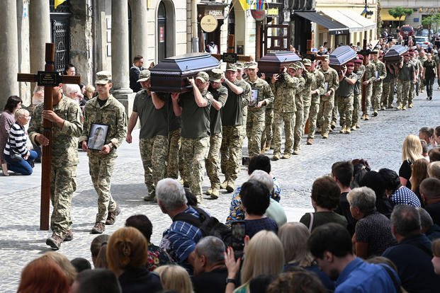 Ukrainian soldiers carry the coffins of 12 Ukrainian servicemen and prisoners of war who died while being held captive in Russia, during a funeral ceremony in Lviv, Ukraine, on July 25, 2025, amid the Russian invasion of Ukraine. 