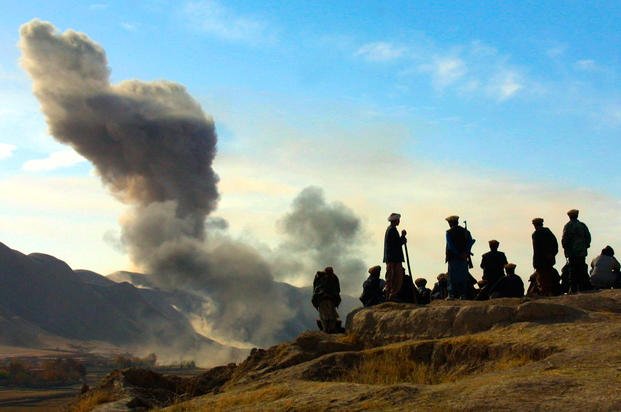 Northern Alliance soldiers watch as U.S. air strikes attack Taliban positions
