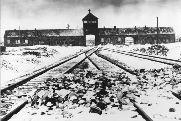 This photo from early 1945 shows the entry to the concentration camp Auschwitz-Birkenau in Poland, with snow-covered rail tracks leading to the camp.