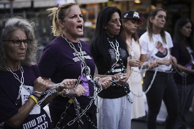 Relatives of Israeli hostages who are being held in the Gaza Strip chain themselves together during a protest.