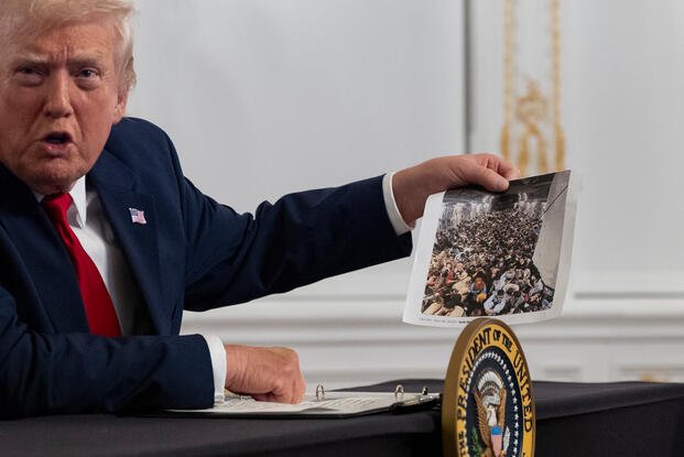 President Donald Trump holds up a photograph.