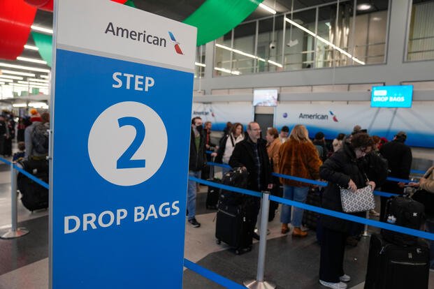 Holiday travelers gather at O'Hare International Airport during Thanksgiving week Wednesday, Nov. 26, 2025, in Chicago. (AP Photo/Erin Hooley)