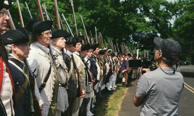 Camera operator films a line of Revolutionary War reenactors for Ken Burns’ PBS docuseries The American Revolution.