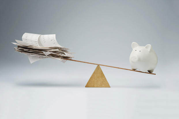 Payday temptation: Piggy bank vs bills on a scale