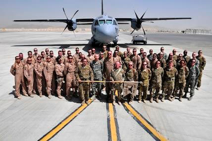 The men and women of the 702nd Expeditionary Airlift Squadron gather for a group photo before the start of their deactivation ceremony at Kandahar Airfield, Afghanistan, on June 18, 2012.