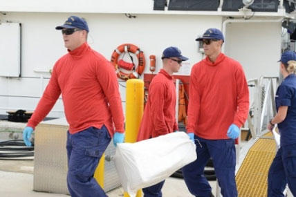 Crew members aboard the Coast Guard Cutter Paul Clark offload bales of marijuana at Coast Guard Sector Miami Dec. 31, 2014. (U.S. Coast Guard photo by Petty Officer 3rd Class Mark Barney)