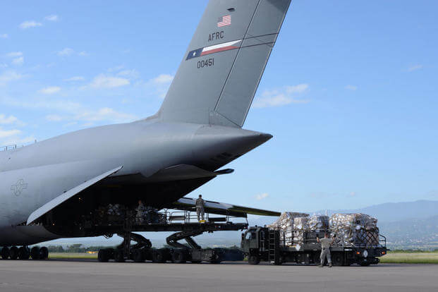 Members of the 612th Air Base Squadron unload humanitarian supplies from a C-5 Galaxy, assigned to the 68th Airlift Squadron, on Soto Cano Air Base, Honduras, Nov. 9, 2015. (U.S. Air Force photo/Senior Airman Westin Warburton)