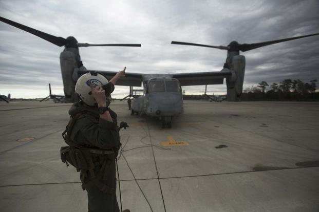 FILE -- A Marine signals towards an MV-22B Osprey on the flightline at Marine Corps Air Station New River, N. C., Feb. 9, 2017. (U.S. Marine Corps photo by Lance Cpl. Raul Torres)
