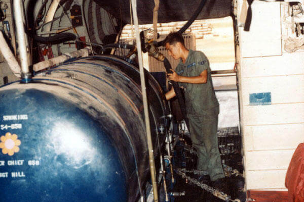 A1C Richard Wolfe checks the herbicide level as it is pumped into the storage tank aboard a UC-123K in 1969. (U.S. Air Force photo)