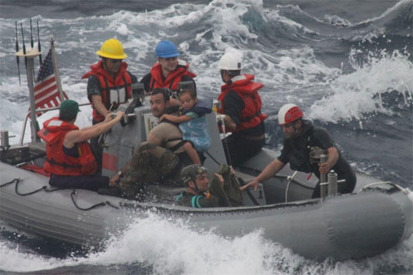 Sailors from Oliver Hazard Perry-class frigate USS Vandegrift (FFG 48) assist in the rescue of a family with a sick infant via the ship's small boat as part of a joint U.S. Navy, Coast Guard and California Air National Guard rescue effort. 