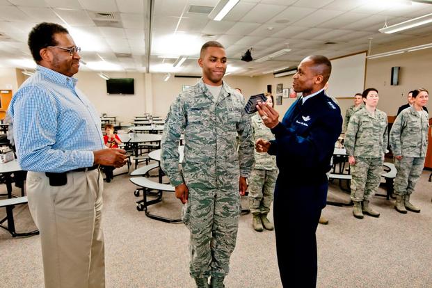 U.S. Air Force Gen. Darren W. McDew, the commander of Air Mobility Command, awards the rank of senior master sergeant to Master Sgt. Brian J. Lovingood, services specialist with the 182nd Force Support Squadron. (U.S. Air Force/Scott Thompson)