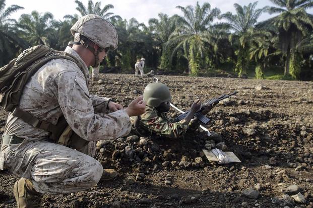 Cpl. Jeremy Osteen shows a Cameroonian soldier an immediate action drill for his weapon while on the range in Limbé, Cameroon, July 1, 2016. (Photo: Cpl. Alexander Mitchell)