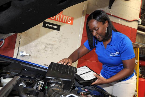 Monique Brisson checks the condition of her car’s air filter at the base Auto Hobby Shop. (U.S. Air Force photo by Tommie Horton)