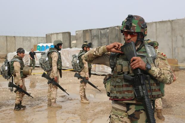 An Iraqi soldier checks his new M16 rifle during an Iraq Train and Equip Fund fielding at Besmaya Range Complex, Iraq, Oct. 29, 2015. (U.S. Army photo/Lakendra Stevens)