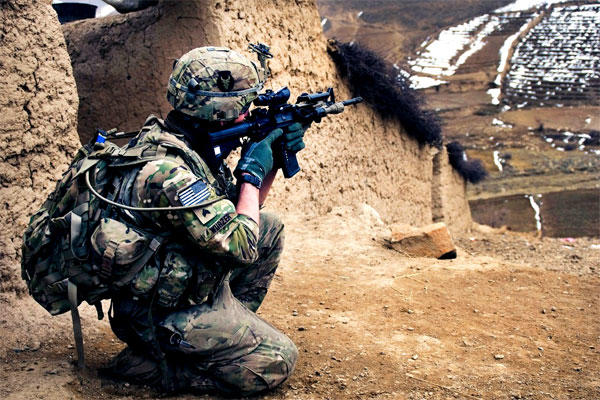 A National Guardsman scans a mountain range while searching a village in Patwan Province, Afghanistan, in 2013. Thousands of Guardsmen who deployed there and in Iraq have been ordered to pay back their re-enlistment bonuses. (US Army photo/Ashlee Lolkus)