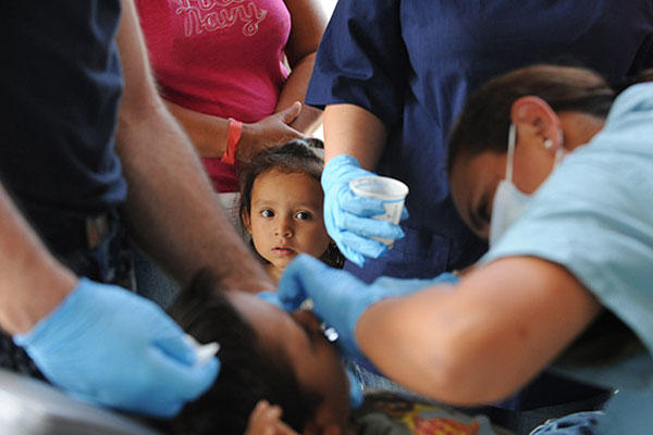 Crew members of the USNS Comfort treat a patient in Acajutla, El Salvador. (DoD Photo/Navy Petty Officer 2nd Class Eric C. Tretter)
