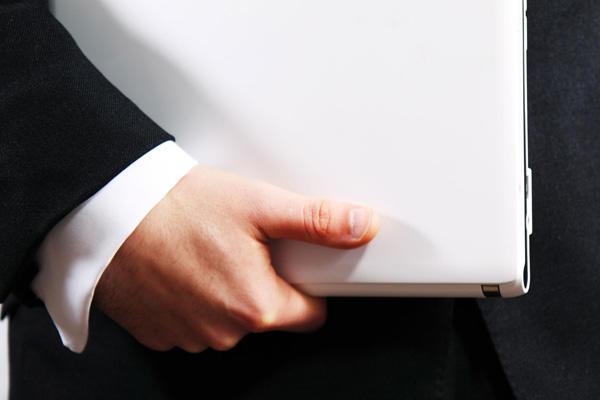 Businessman holding a white laptop.