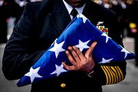 Command Master Chief Huben Phillips prepares to present the ensign during a burial-at-sea ceremony aboard the aircraft carrier USS George H.W. Bush (CVN 77). (U.S. Navy/Hank Gettys)