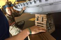 The Junior Force Warfighters Operations in the Air Force Research Laboratory Materials and Manufacturing Directorate discuss replacing the old 85-pound milk stool for the C-130 aircraft with Tech. Sgt. Shawn Cooper. (U.S. Air Force/Capt. Jason Goins)