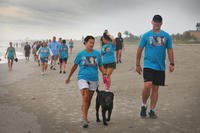 Air Force veteran Stacey Pavenski, left, 46, of Palm Bay, Florida, walks on the beach with her therapy dog, Memphis Bellw during a 3K she organized. (Photo courtesy of Florida Today via DVIDS)