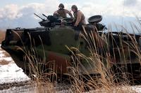 Assault amphibious vehicle crew members instruct Pfc. Nathan E. Craig, center, on how to operate an AAV on Jan. 24, 2013, in the North Fuji Maneuver Area at Combined Arms Training Center Camp Fuji on mainland Japan. The Combat Assault Battalion is deactivating after 76 years. Cpl. Matthew Manning/Marine Corps