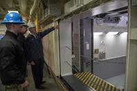 Secretary of the Navy Richard V. Spencer is briefed by Lt. Cmdr. Chabonnie Alexander, USS Gerald R. Ford’s ordnance handling officer, on the advanced weapons elevator during a tour of the carrier, Jan. 17, 2018. (U.S. Navy/Mass Communication Specialist 2nd Class Kiana A. Raines)