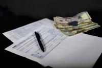 A 1040 tax form sits next to a small bit of cash. (U.S. Air Force/Senior Airman Valerie Halbert)