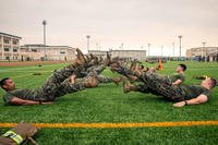 U.S. Marines with Headquarters and Headquarters Squadron conduct flutter kicks during a squadron physical training event at Marine Corps Air Station Iwakuni, Japan, July 26, 2019. (U.S. Marine Corps/Lauren Brune)