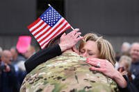 An Airman embraces his wife as she cries.