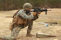 An infantry Marine with 1st Battalion, 6th Marines, peers through the Squad Common Optic during a Limited User Evaluation.