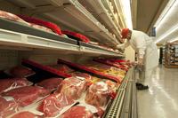 An Altus AFB Commissary meat cutter places packaged meat in the main store.