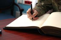 close up of a hand writing in a book