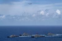 USS Detroit travels in formation with  USS Lassen, USS Preble, USS Farragut and a P-8A aircraft.