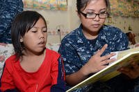 a sailor reads to a young girl