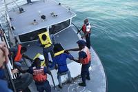 Haitian officials transfer migrants from Coast Guard Cutter Resolute.