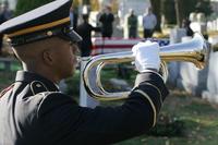 An Army soldier plays taps in the Cypress Hills National Cemetery.