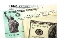 Cash and check with tax form signifying tax refund
