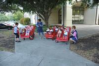 Members from the Child Development Center take children for a stroller ride.