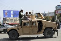 Taliban fighters stand guard in front of the Hamid Karzai International Airport