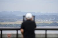 visitor uses binoculars to see the North Korean side from the unification observatory in South Korea