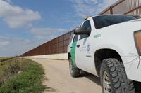 A U.S. Customs and Border Protection truck sits by the border wall along the Rio Grande River.